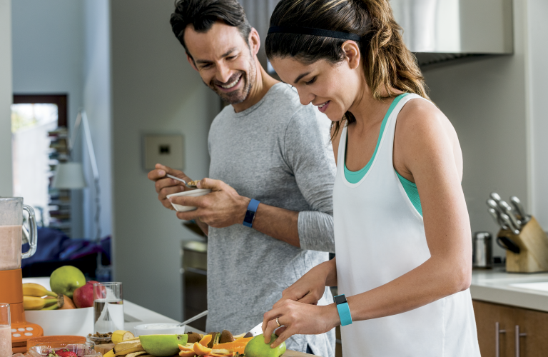 Man and woman cutting fruit together