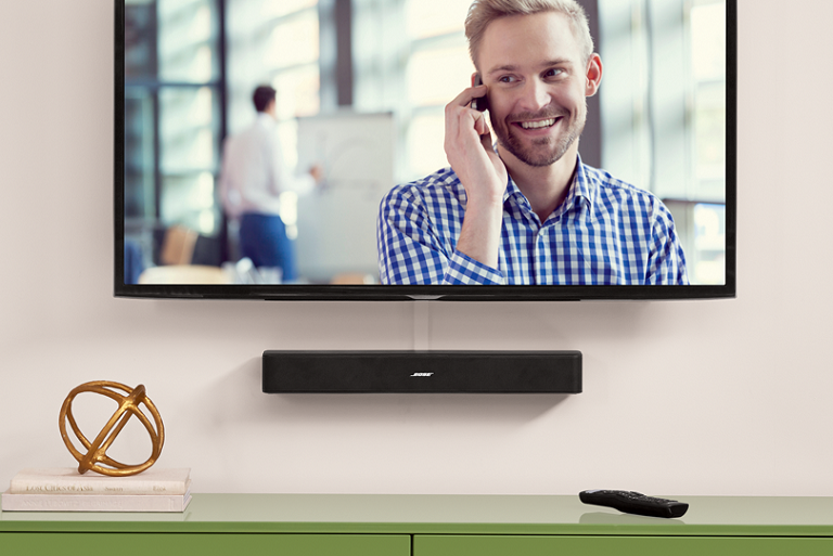 The Bose Sound System moutne on a wall beneath a TV