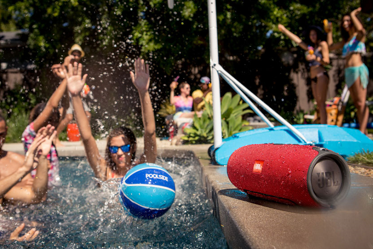 The JBL bluetooth speaker playing music at a pool party