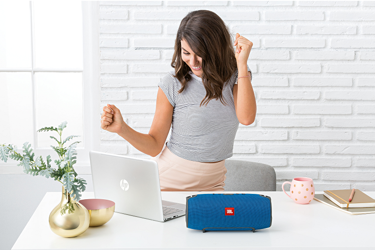 A woman dancing to music on the JBL Xtreme Speaker